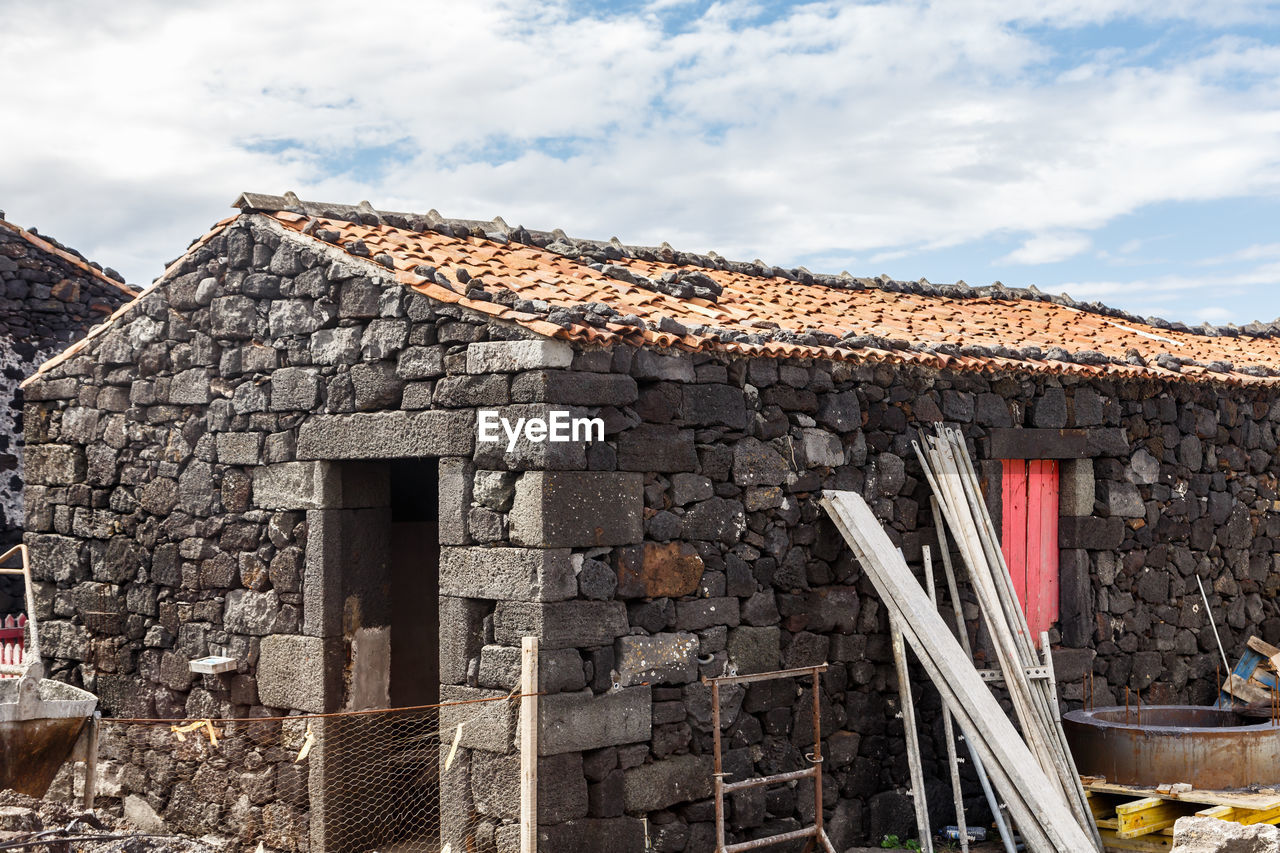 Old stone building against cloudy sky