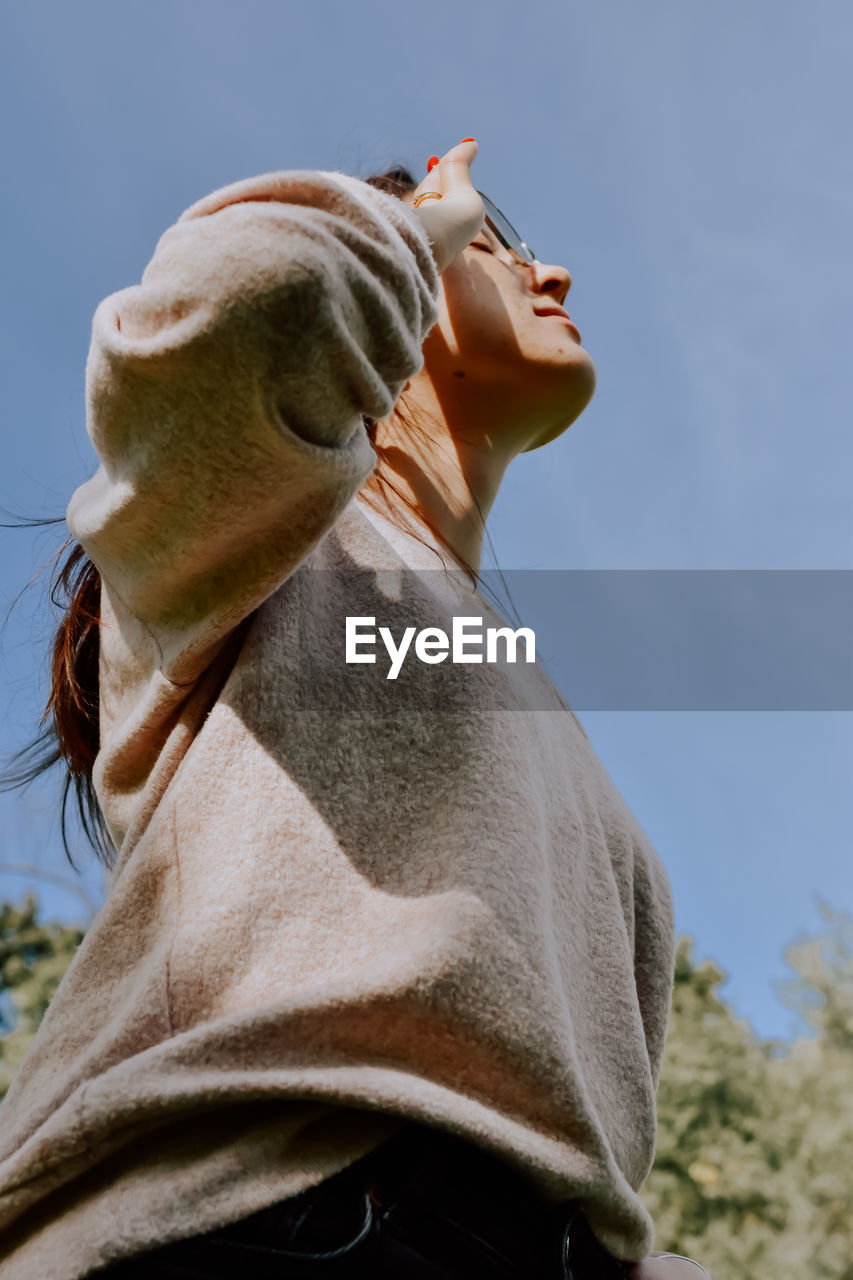 Low angle view of woman using mobile phone