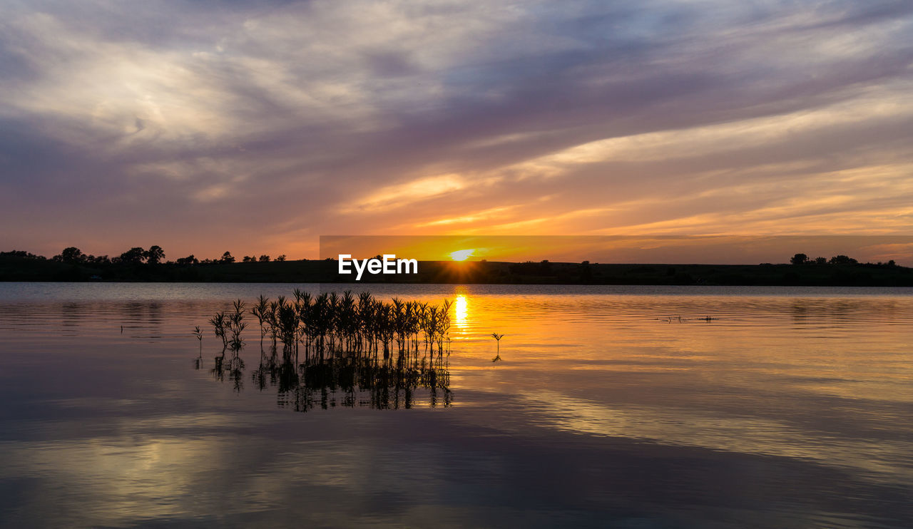 Scenic view of lake against sky during sunset