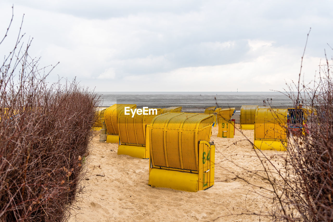 Sandy beach and typical hooded beach chairs in cuxhaven in the north sea coast a cloudy day, summer