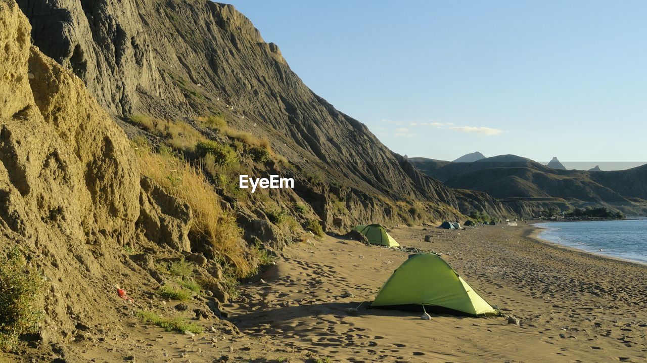 SCENIC VIEW OF SEA AGAINST MOUNTAIN