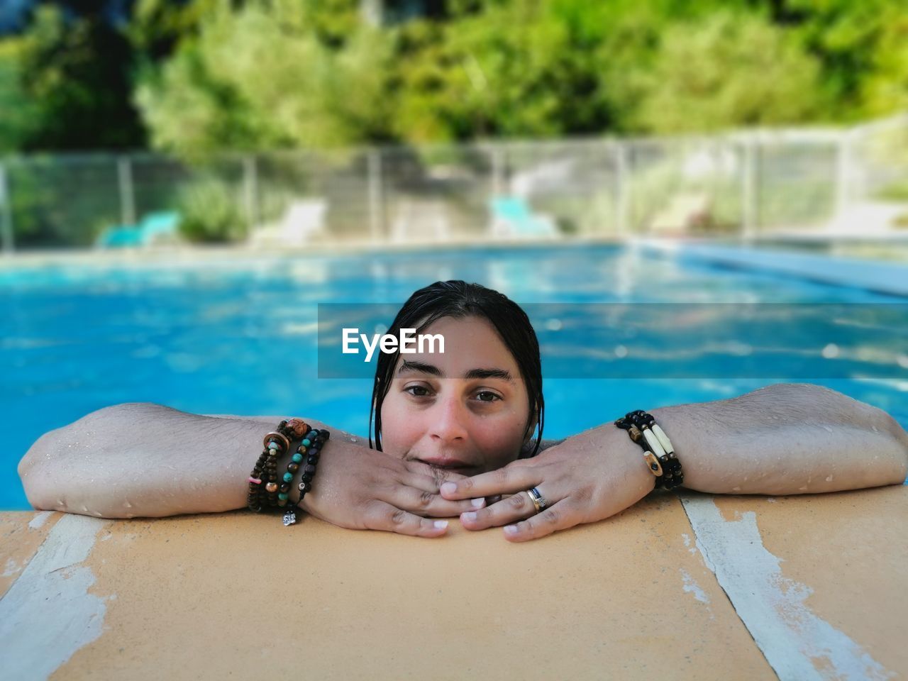 PORTRAIT OF YOUNG WOMAN WITH SWIMMING POOL