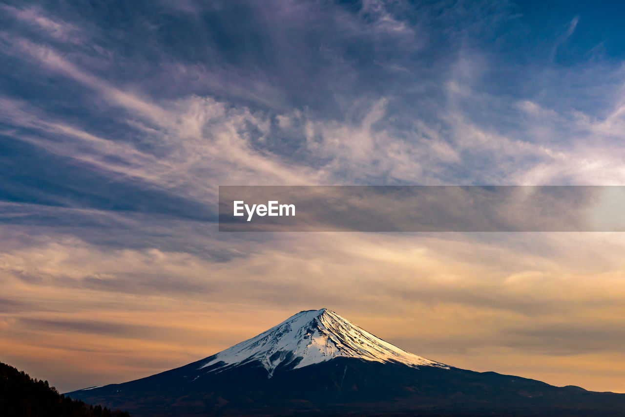 Scenic view of snowcapped volcano against sky during sunset