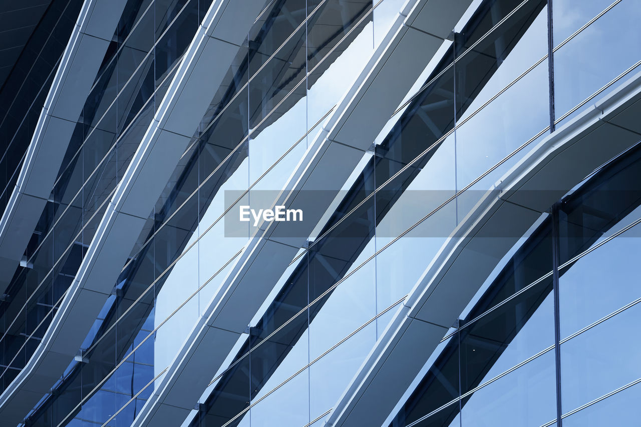 LOW ANGLE VIEW OF GLASS BUILDING AGAINST SKY