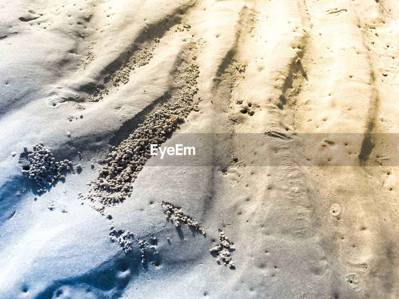 HIGH ANGLE VIEW OF TIRE TRACKS ON SAND