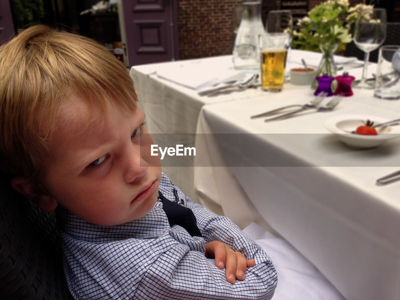 Close-up portrait of angry boy sitting at dining table