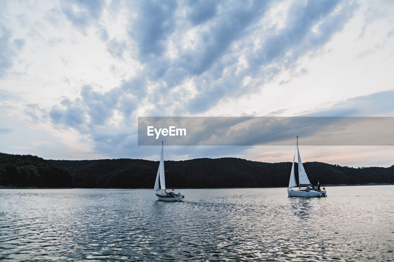 SAILBOATS SAILING ON SEA AGAINST SKY