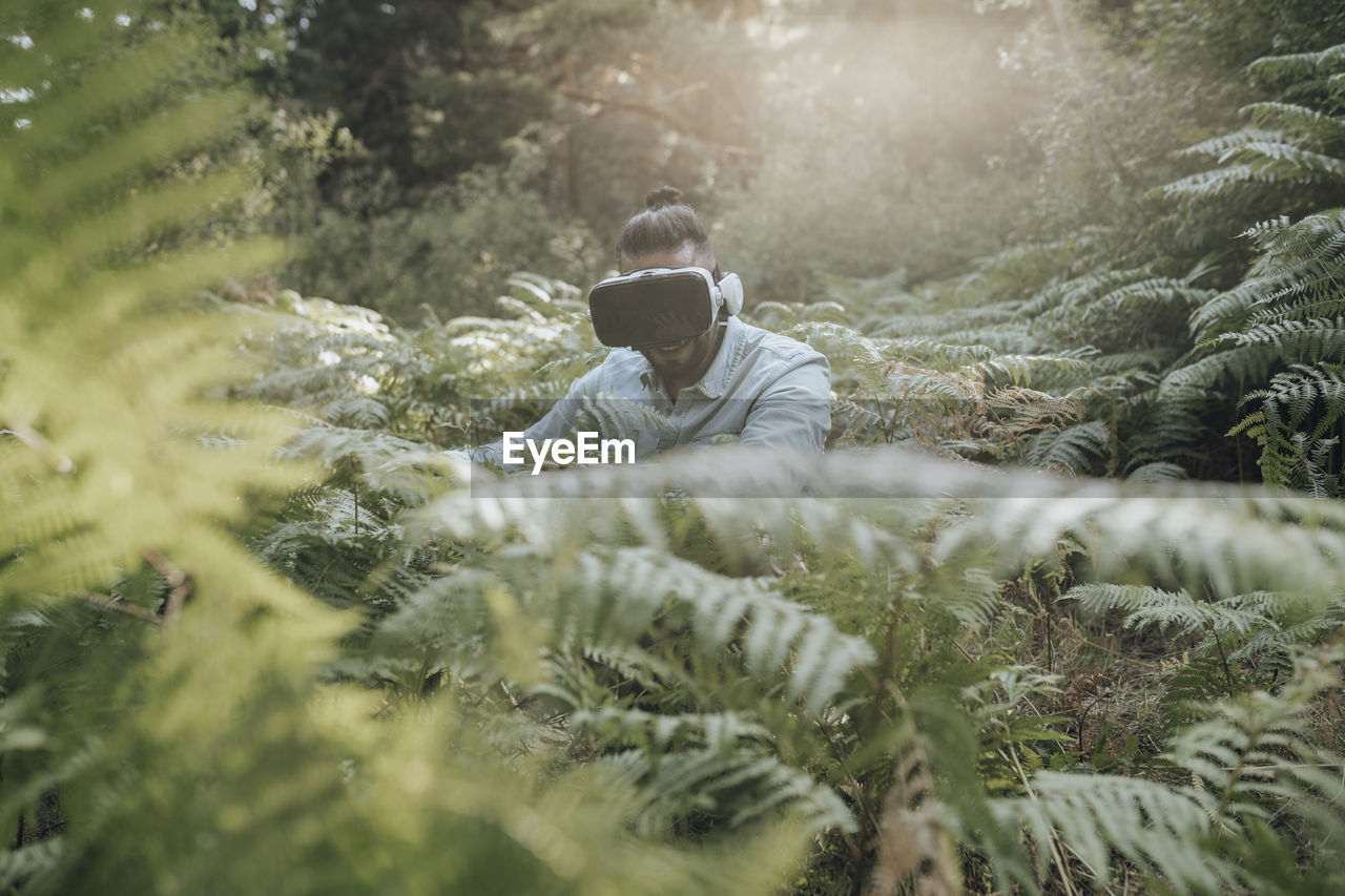 Man using virtual reality headset while exploring forest