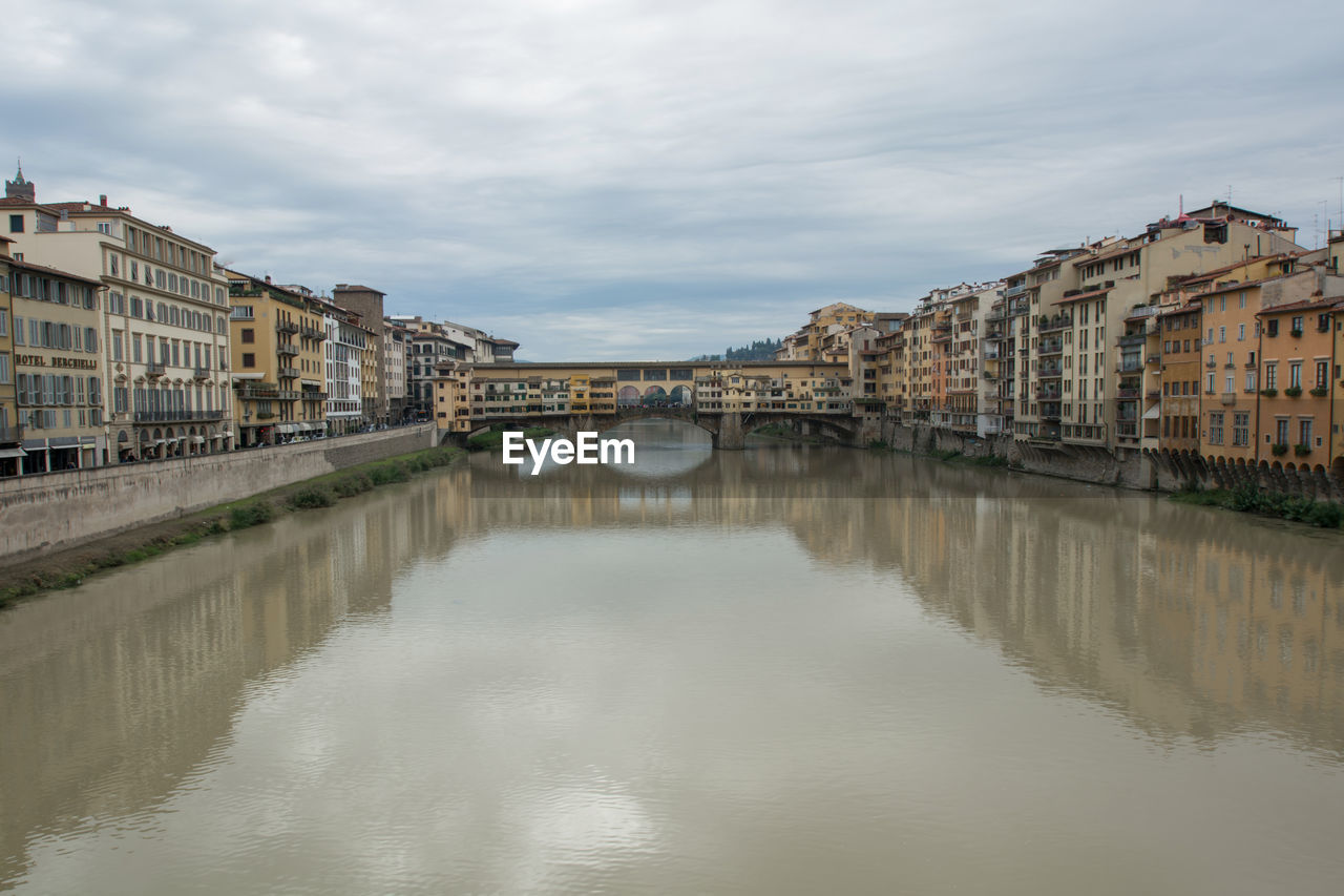 View of canal in city against sky