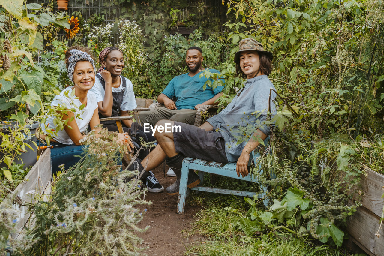 Portrait of male and female farmers sitting in organic farm