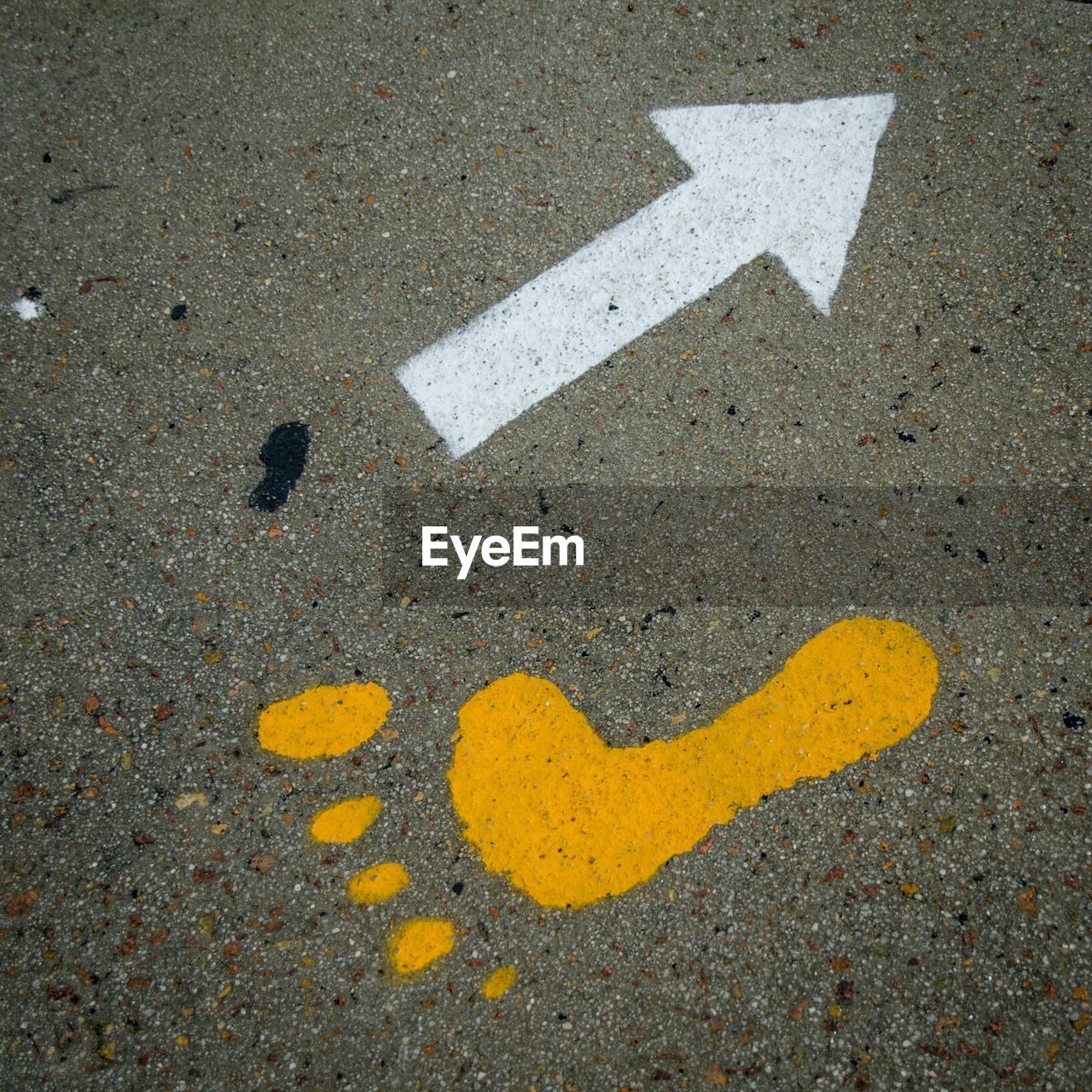 Close-up of human footprint and arrow symbol