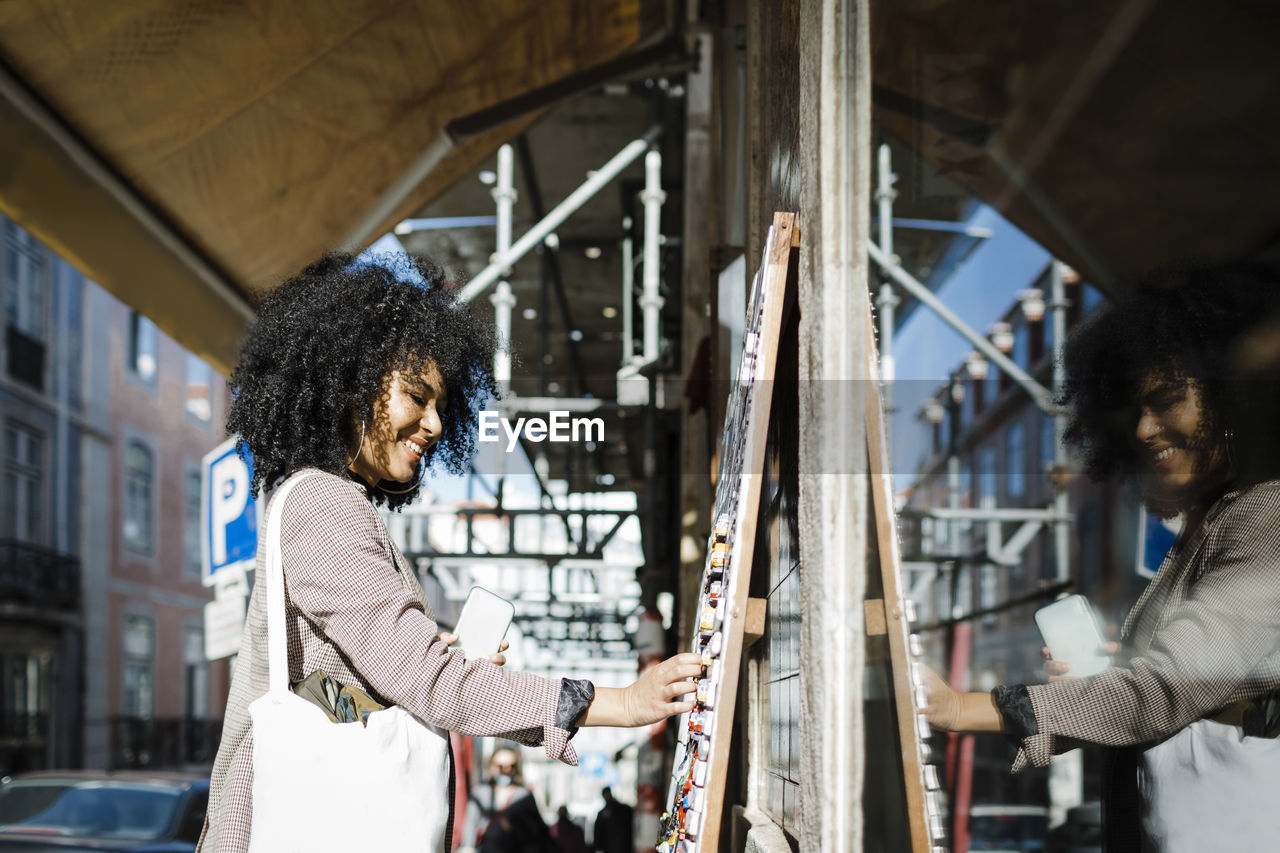 Happy young woman shopping outside store