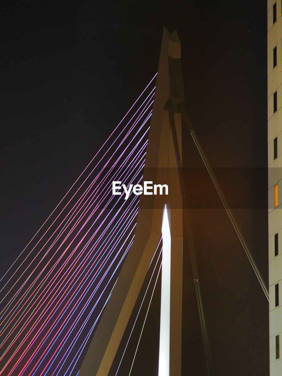 LOW ANGLE VIEW OF ILLUMINATED SUSPENSION BRIDGE