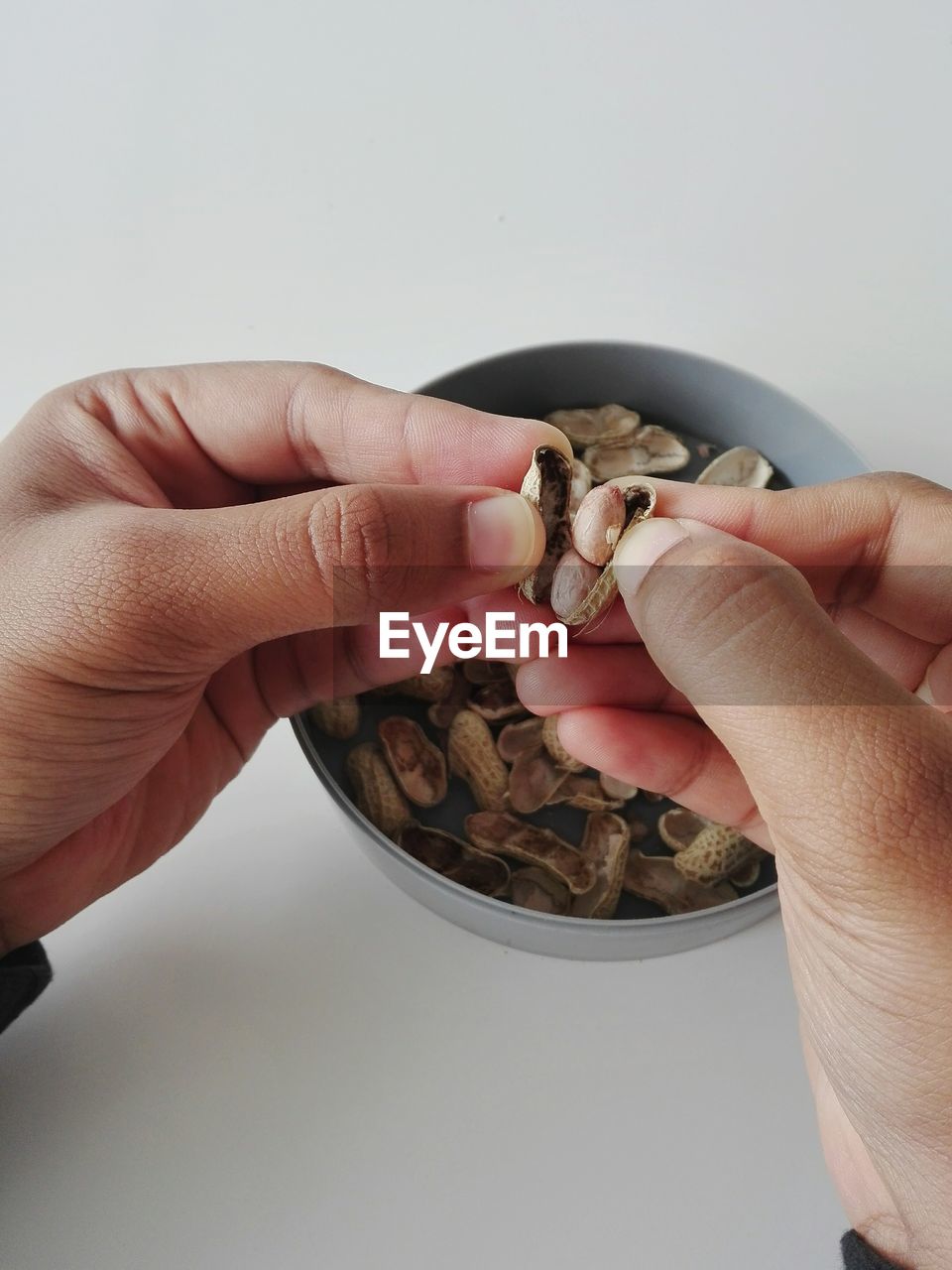 Close-up of man holding peanut 