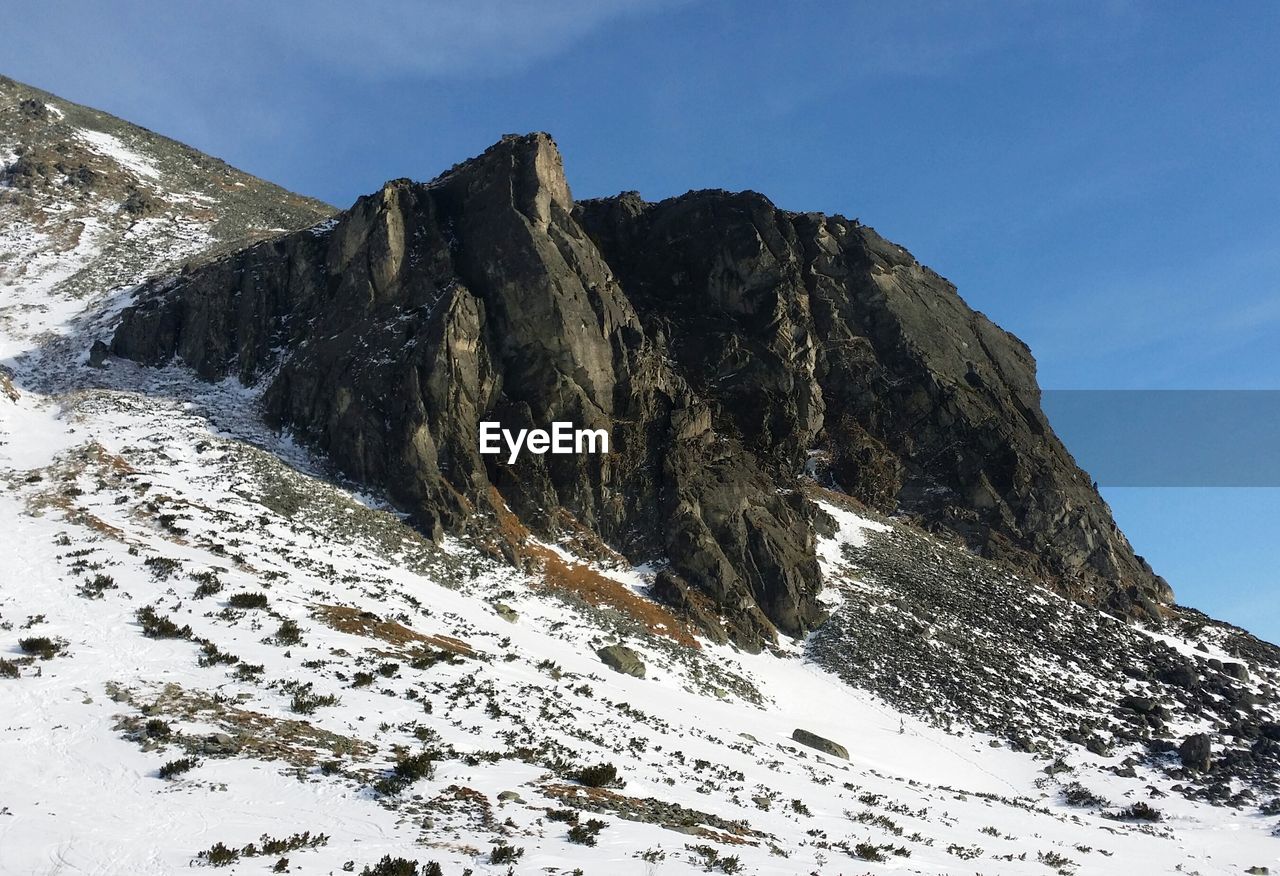 Low angle view of snowcapped mountain against sky