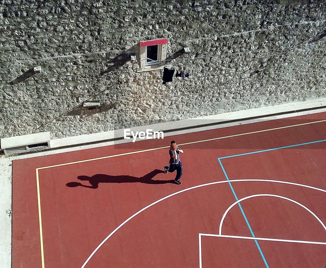 High angle view of man playing basketball against wall