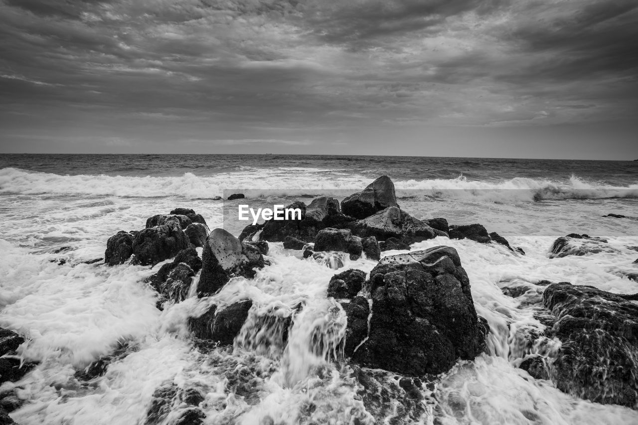 Rocks in sea against sky