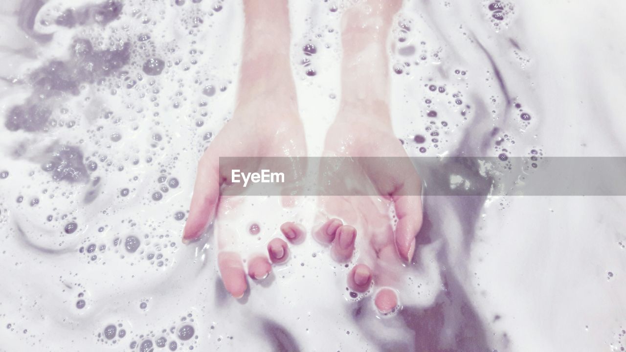 WOMAN STANDING IN WET WATER