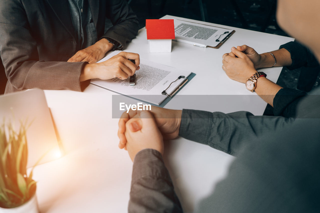 Midsection of real estate agent using rubber stamp on table 