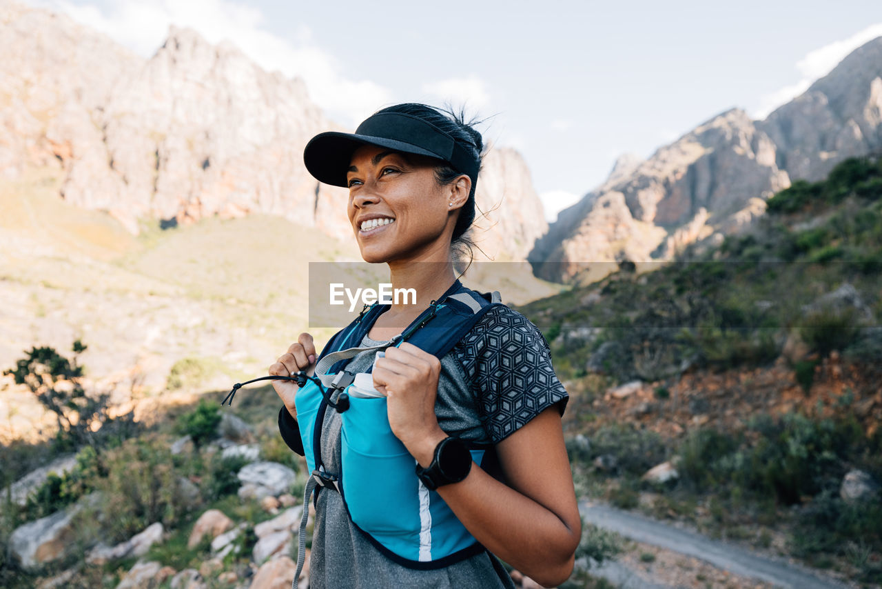 Happy woman standing against mountain