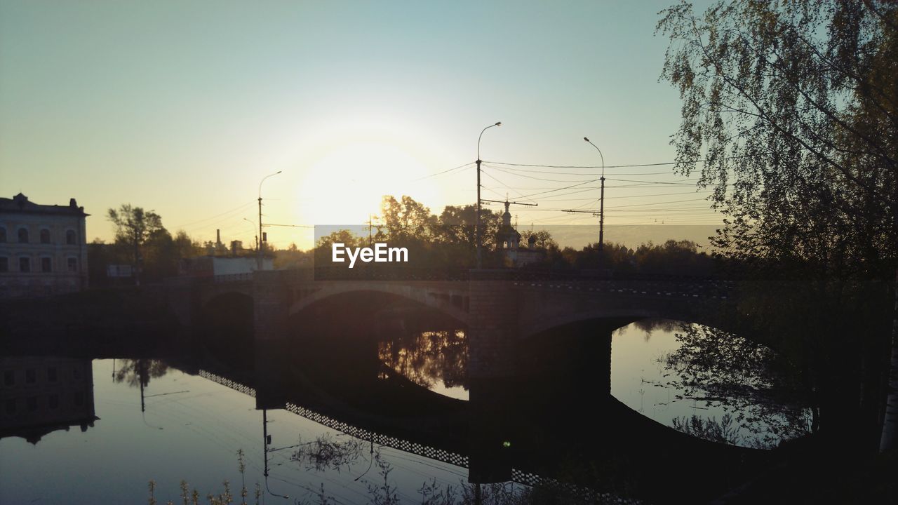 REFLECTION OF CITY ON LAKE DURING SUNSET