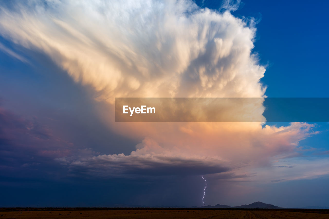 Lightning strikes from a thunderstorm over ironwood forest national monument at sunset.