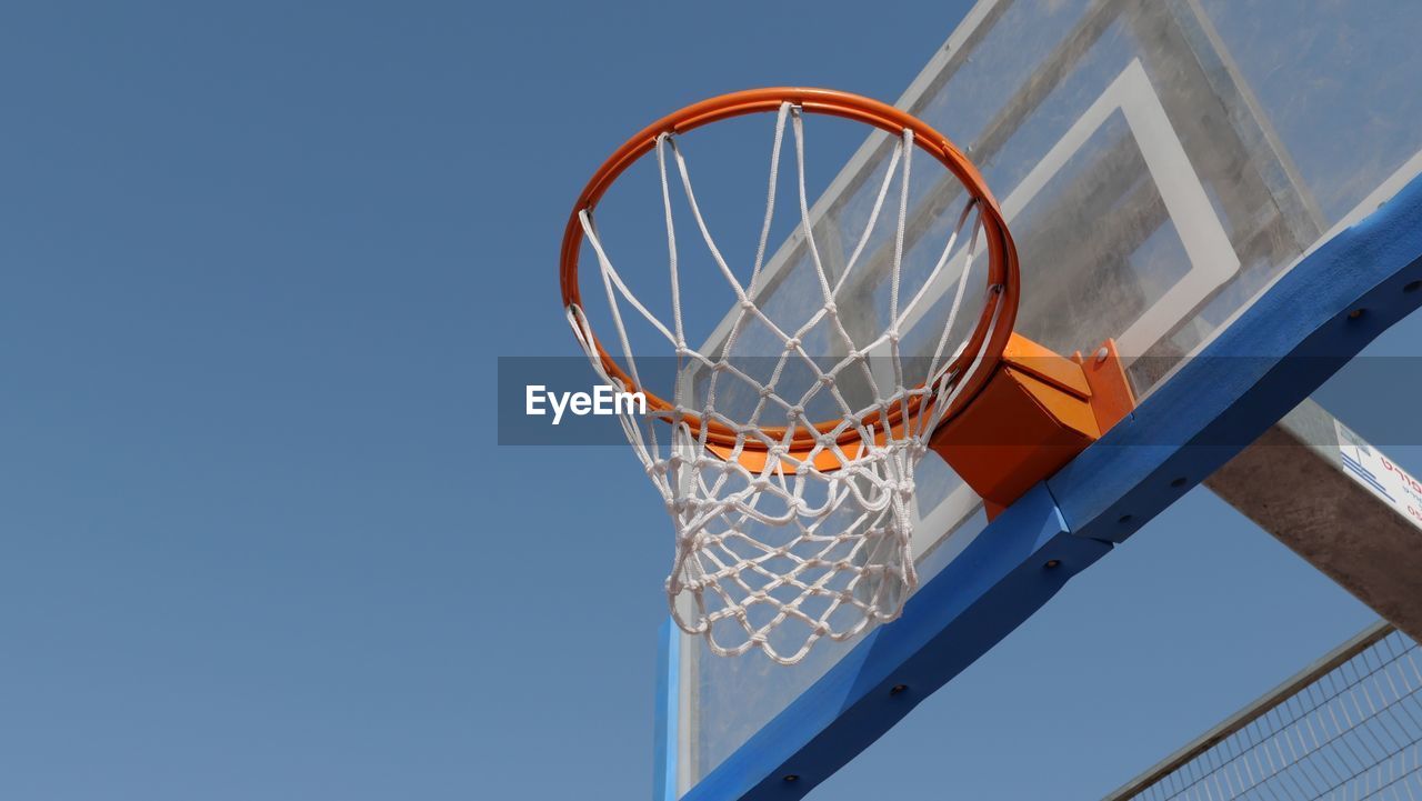 Basketball hoop against clear blue sky
