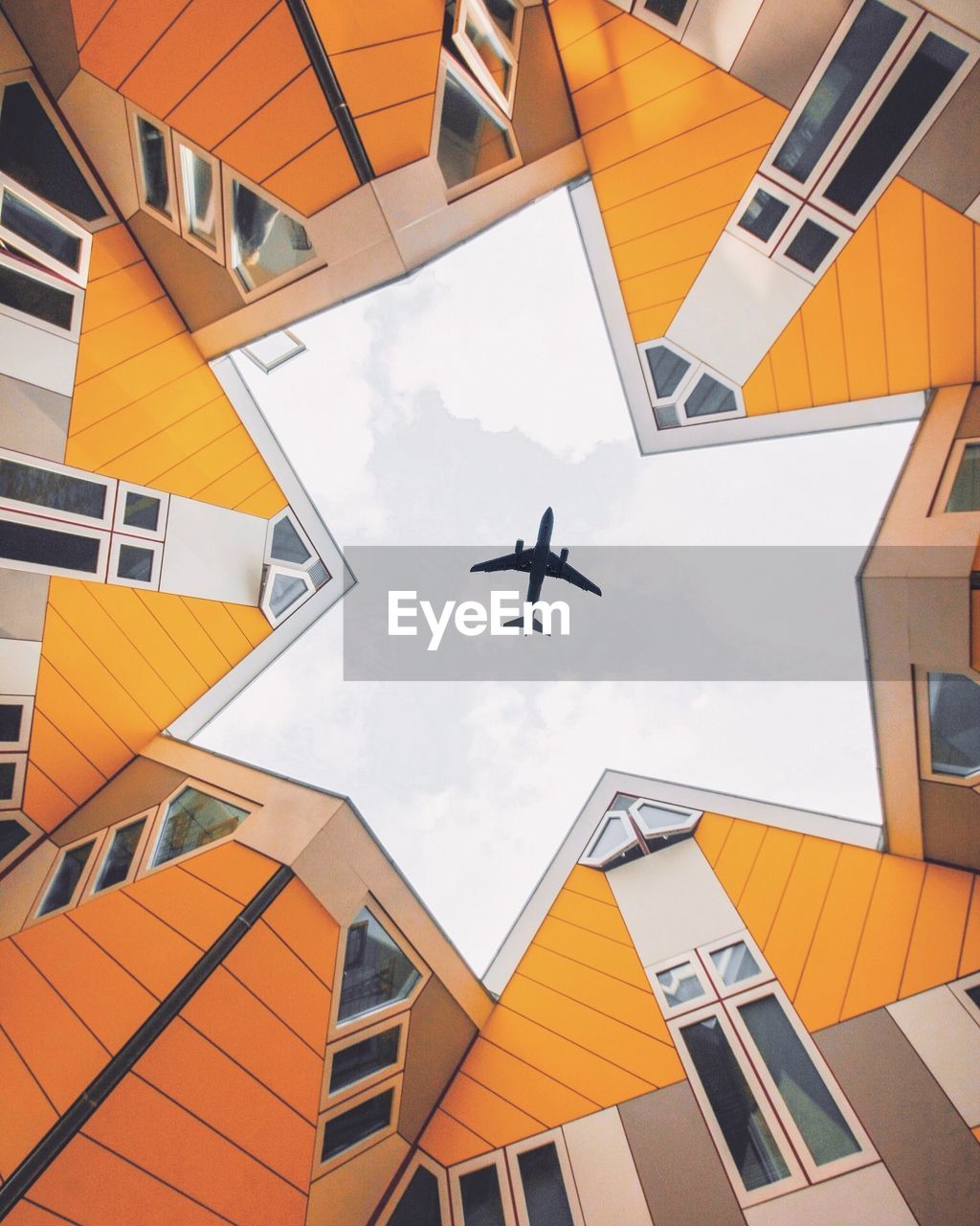 LOW ANGLE VIEW OF AIRPLANE FLYING OVER BUILDINGS