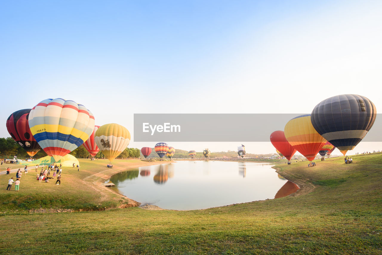 Hot air balloons over landscape against sky