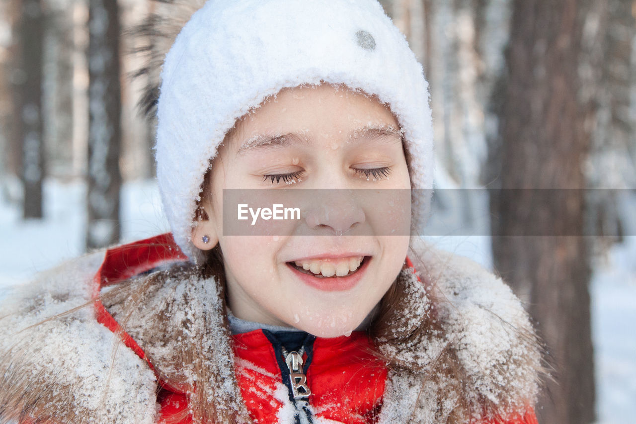 PORTRAIT OF SMILING BOY WITH SNOW