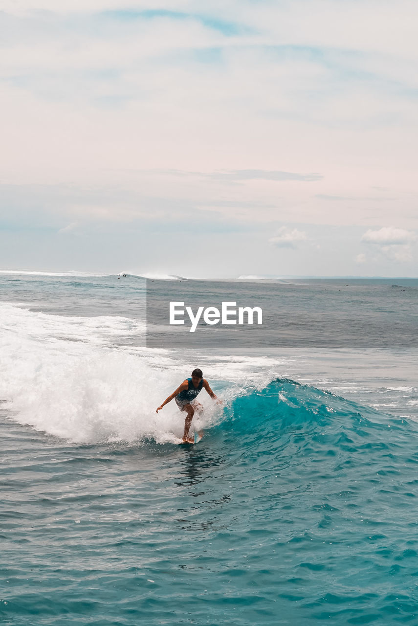 Man surfing in sea against sky