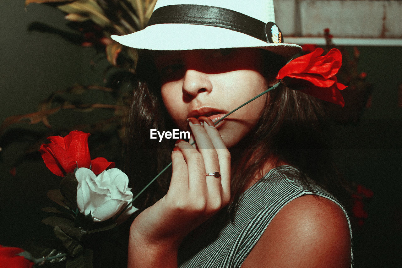 Close-up portrait of teenage girl holding artificial flower