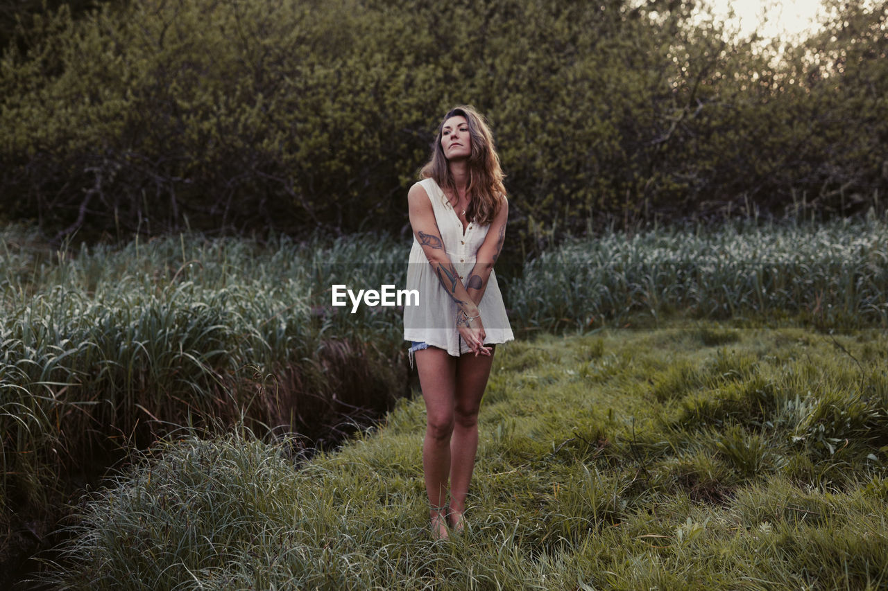 Natural beauty with tattoos in a meadow in ucluelet