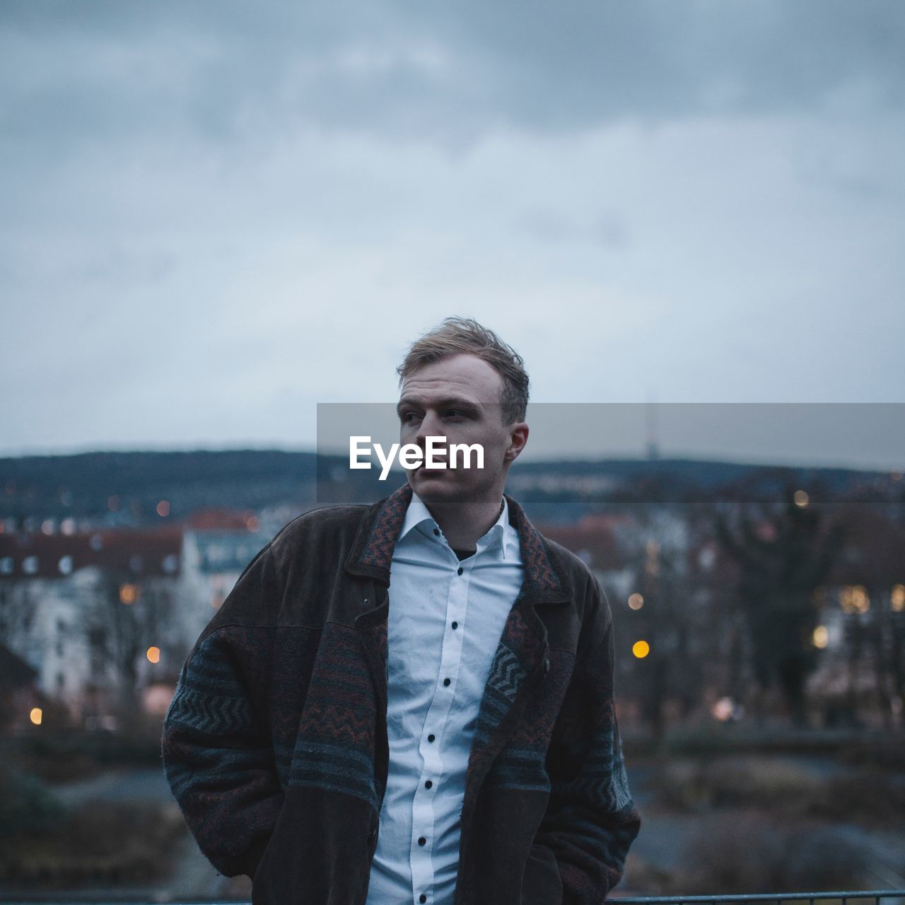 Young man looking away against sky