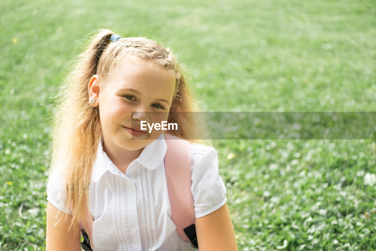 portrait of smiling young woman standing on field