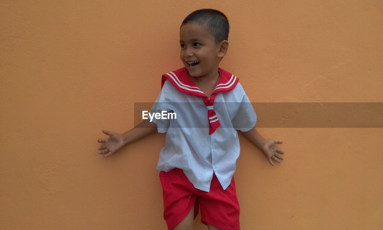 Boy standing against wall