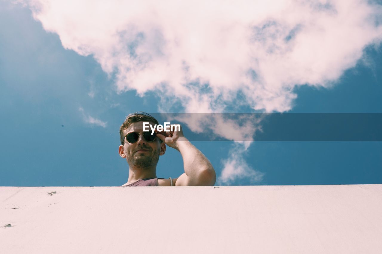 Low angle view of young man against sky