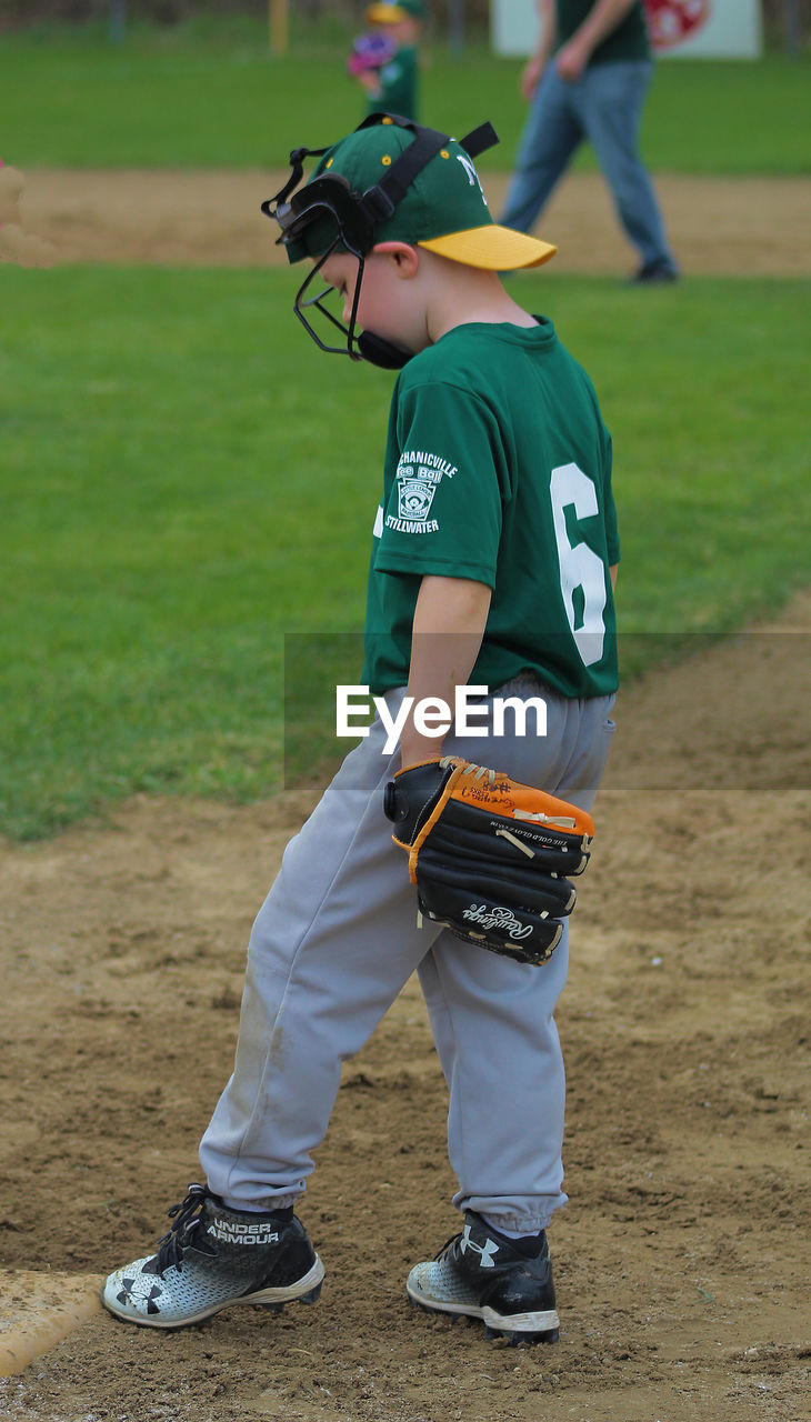 FULL LENGTH OF BOYS STANDING ON FIELD