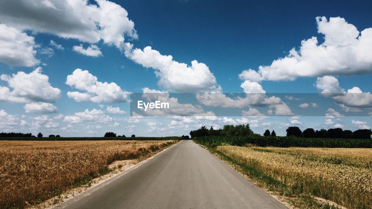 EMPTY ROAD ALONG FIELD