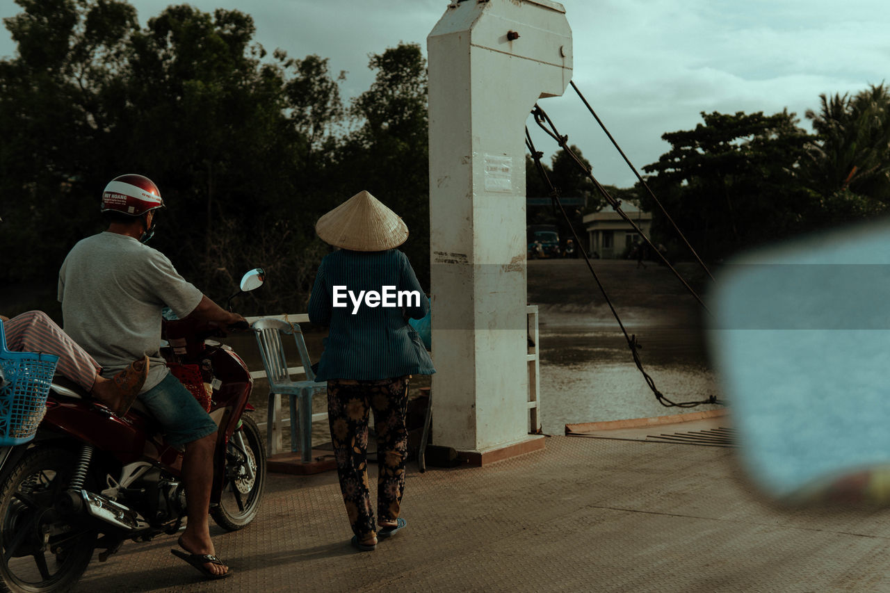 transportation, adult, men, mode of transportation, full length, vehicle, bicycle, tree, sports, person, nature, two people, city, clothing, sky, road, architecture, rear view, street, plant, motion, hat, activity, outdoors, lifestyles, land vehicle, headwear, on the move, cloud, day, helmet