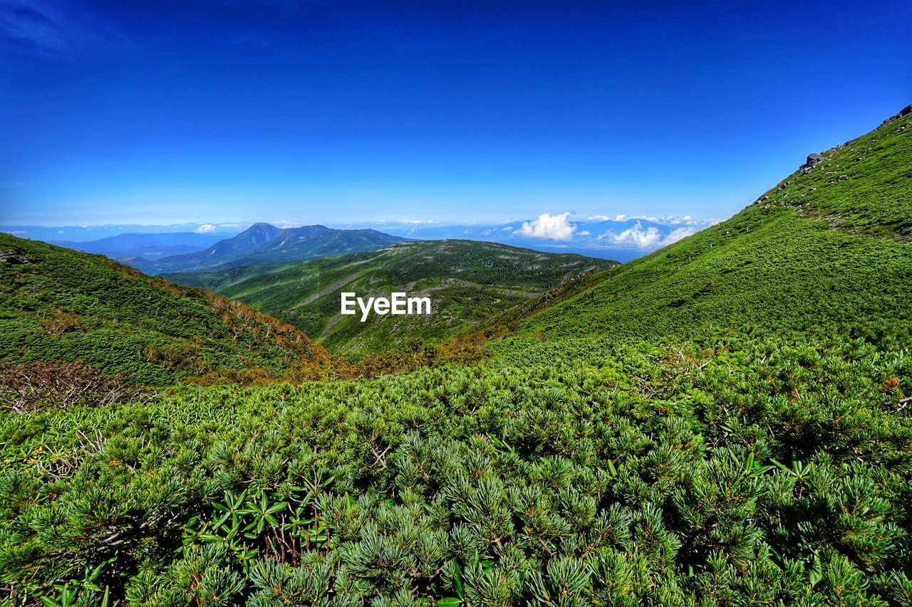 Scenic view of mountains against blue sky