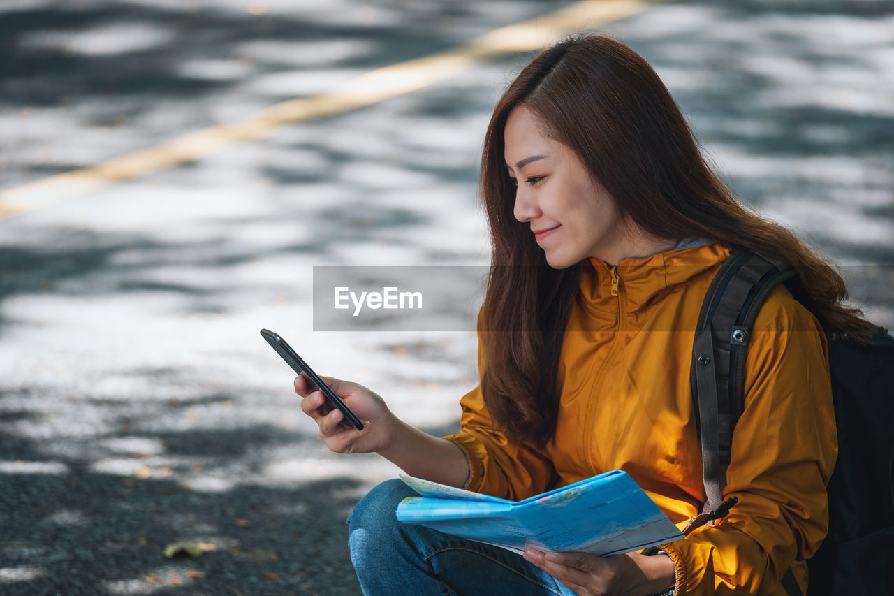 YOUNG WOMAN USING MOBILE PHONE