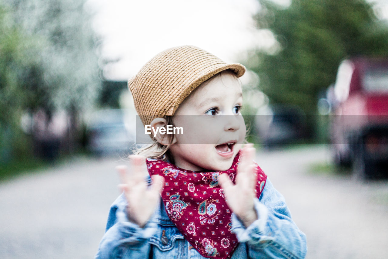 Close-up of cute girl gesturing on road