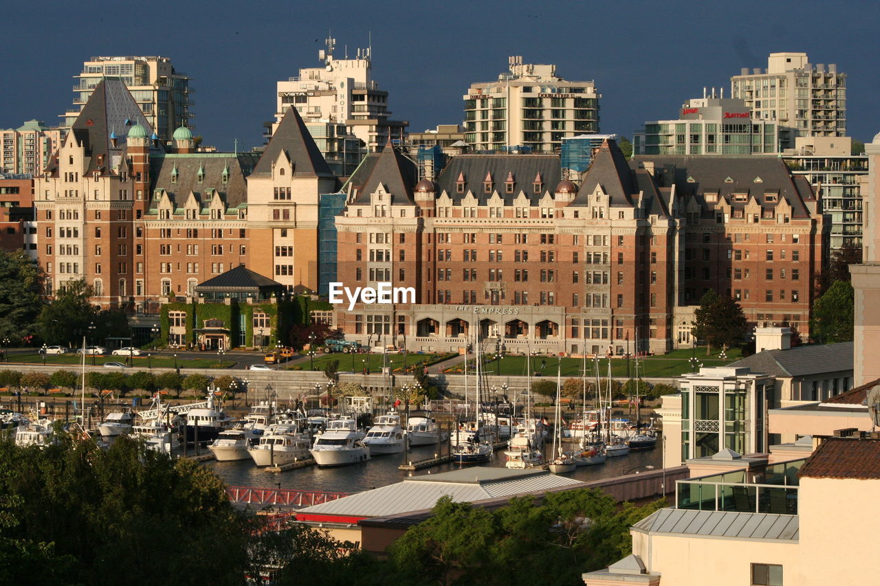 Boats moored in river against buildings