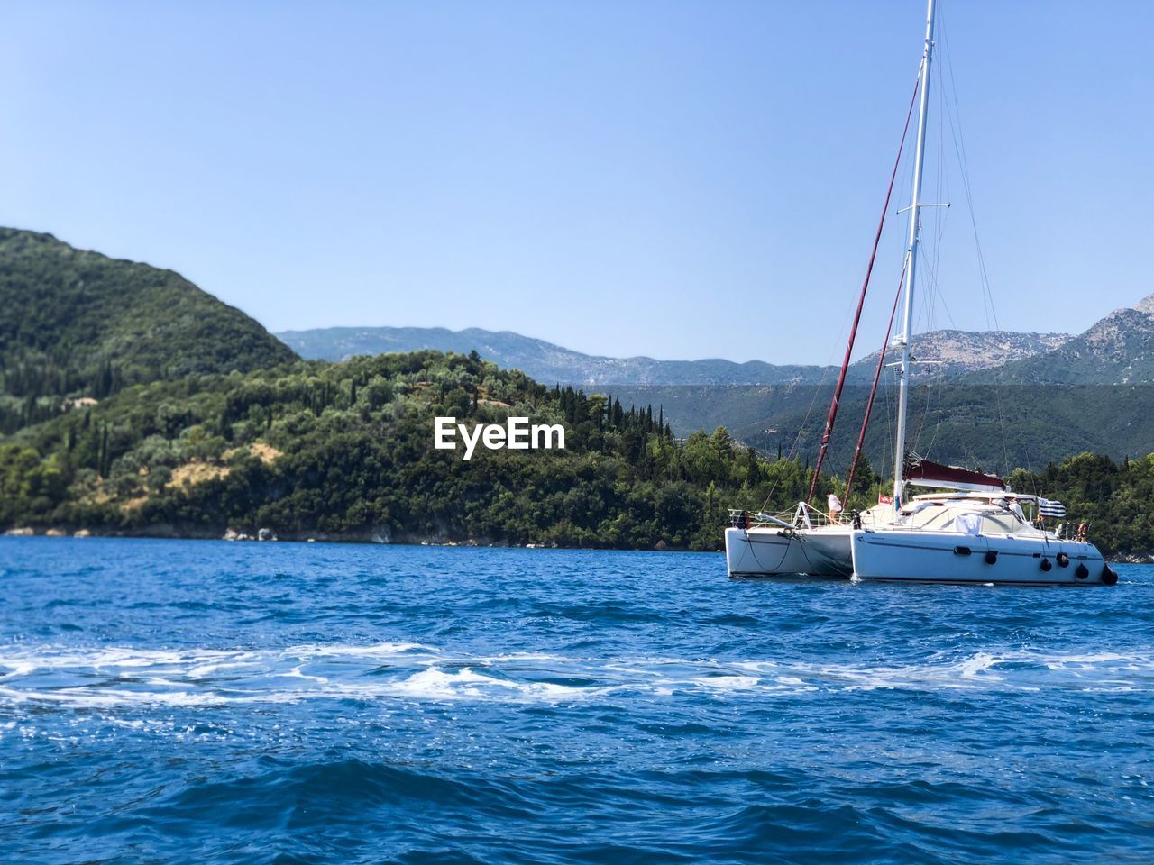 Sailboat sailing on sea against clear sky