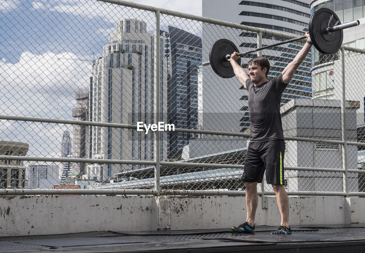 Man training at rooftop gym in bangkok