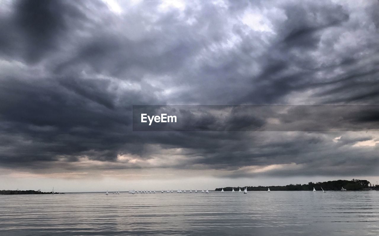 SCENIC VIEW OF SEA AGAINST STORM CLOUDS IN SKY