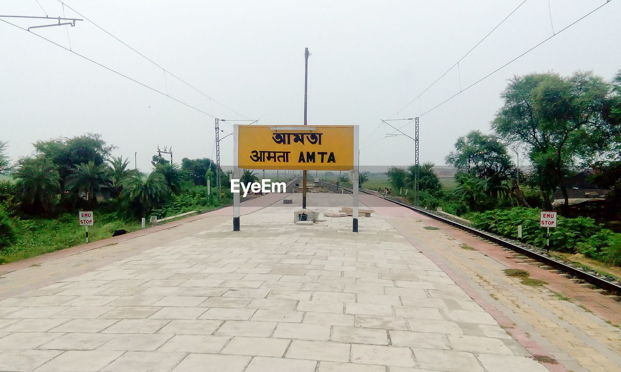 INFORMATION SIGN ON FOOTPATH BY PLANTS AGAINST SKY