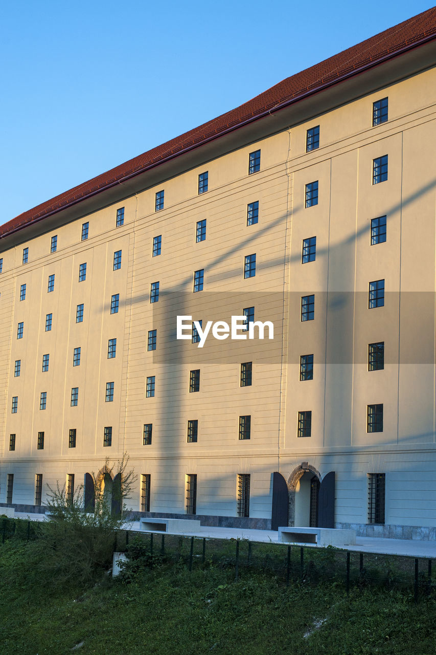 LOW ANGLE VIEW OF MODERN BUILDING AGAINST CLEAR BLUE SKY