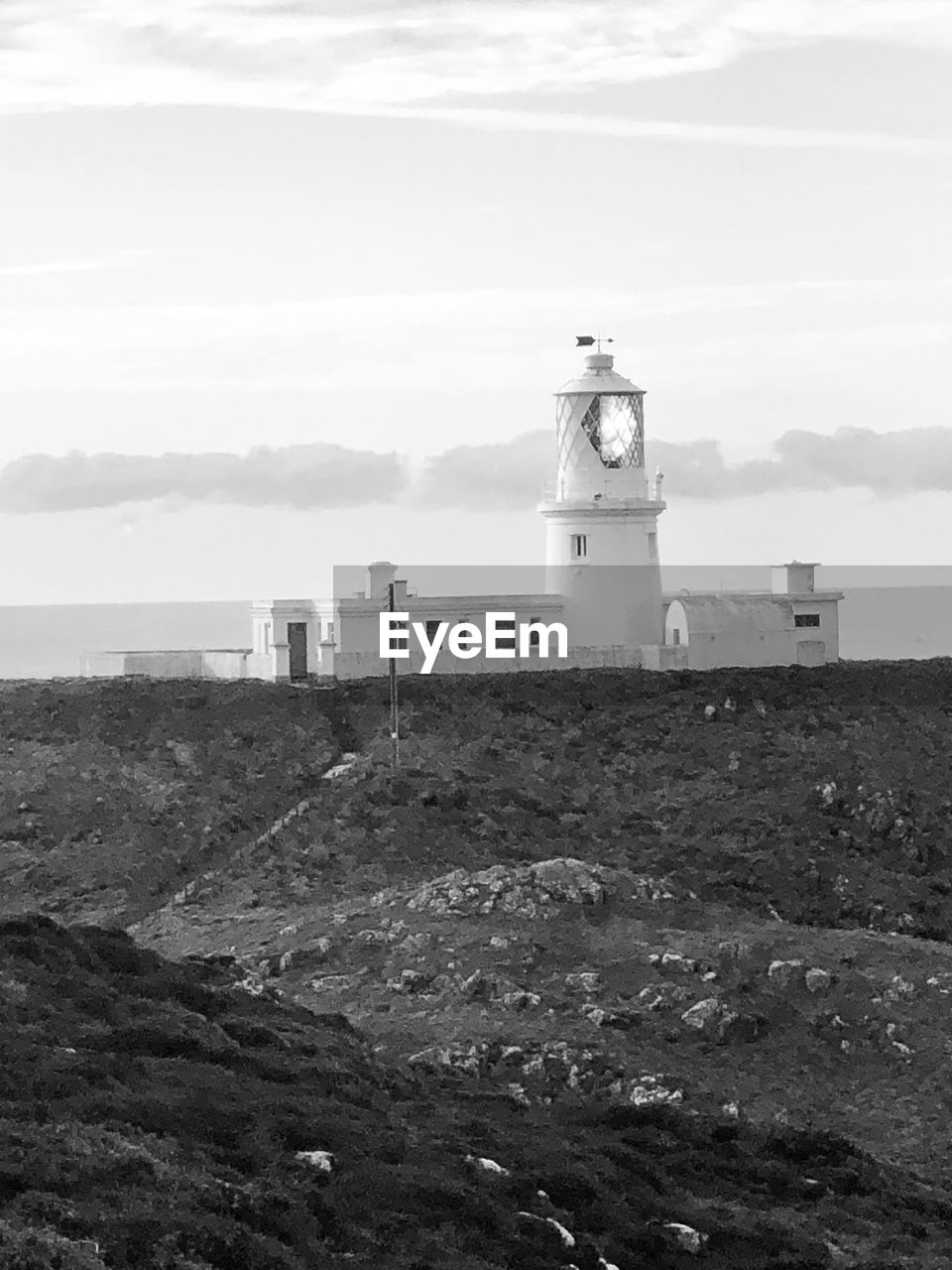 LIGHTHOUSE BY SEA AGAINST BUILDING